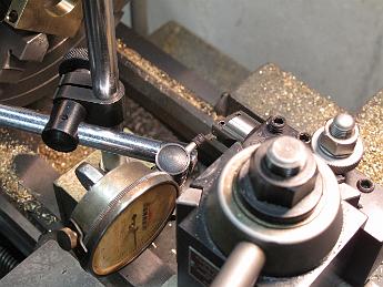  Using a dial-test indicator to insure the side of the cutter is parallel to the ways, insuring the groove is cut to the proper depth.